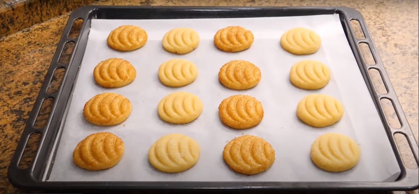 Masa de galletas de naranja dispuesta en una bandeja de horno usando manga pastelera
